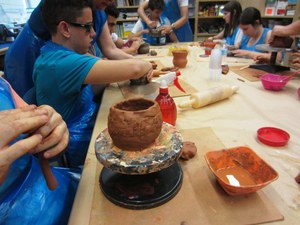Los escolares intentando crear un vaso campaniforme a partir de metrial de arcilla