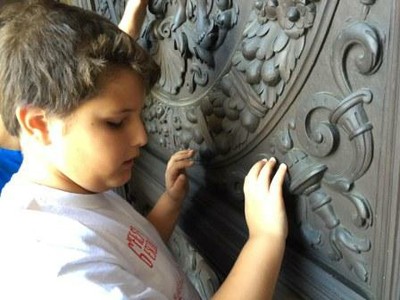 Uno de los escolares más pequeños reconociendo al tacto un relieve de hierro