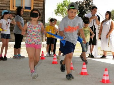Dos pequeños (la niña con sus ojos tapados con un antifaz) realizan una 'carrera a ciegas'