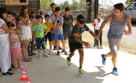 Un monitor guía a uno de los chavales en una 'carrera a ciegas'