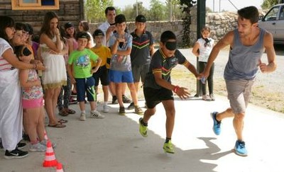 Un monitor guía a uno de los chavales en una 'carrera a ciegas'