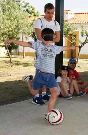 Uno de los chavales (provisto de antifaz) intenta chutar en una práctica de fútbol a ciegas