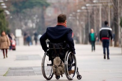 Una persona en silla de ruedas pasea por una zona céntrica de una ciudad