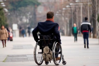 Una persona en silla de ruedas pasea por una zona céntrica de una ciudad