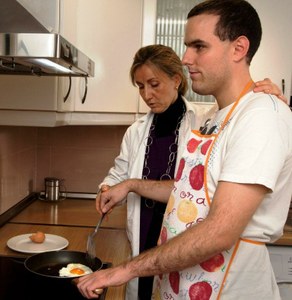 Una técnico de Rehabilitación enseña a un joven ciego las habilidades para freír un huevo 
