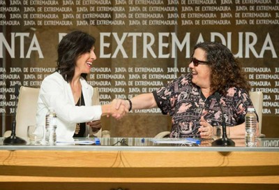 La consejera extremeña (a la izquierda) sella el acuerdo con un apretón de manos con la responsable de Educación de la ONCE
