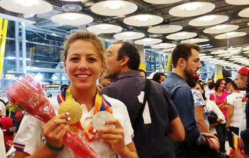 La nadadora Nuria Marqués muestra sus dos medallas en el multitudinario recibimiento al equipo en Barajas