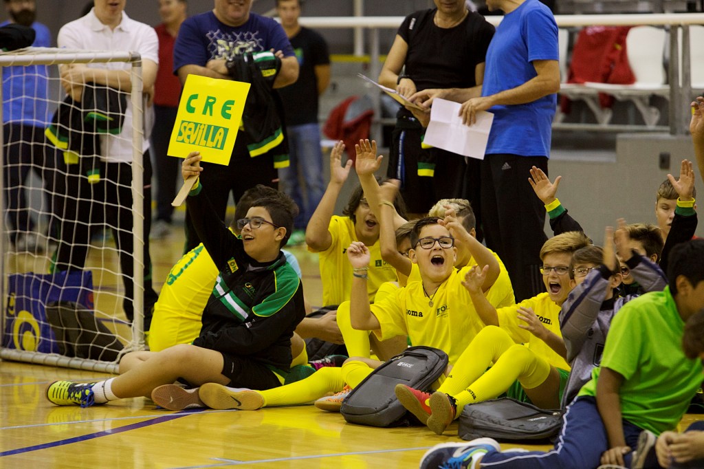 Niños del CRE de Sevilla levantan los brazos en señal de alegría en el polideportivo