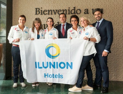 Las tripulantes del velero recogiendo la bandera de ILUNION Hotels
