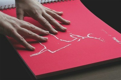 Manos sobre un libro en braille y en relieve