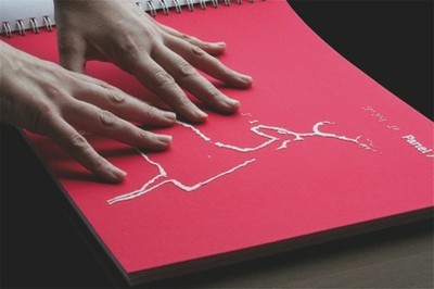 Manos sobre un libro en braille y en relieve