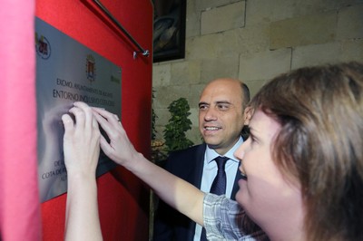Una persona ciega toca la placa en braille de la cota de Alicante