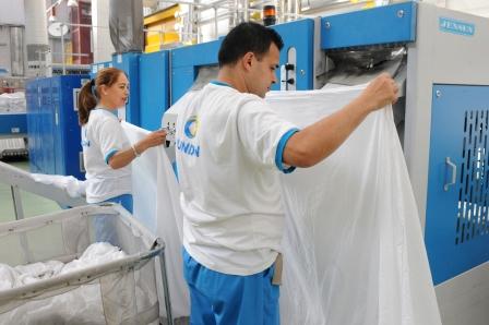 Un momento de la cadena de producción en una planta de lavado industrial de ILUNION, uno de los sectores en los que nuestro grupo es líder nacional 