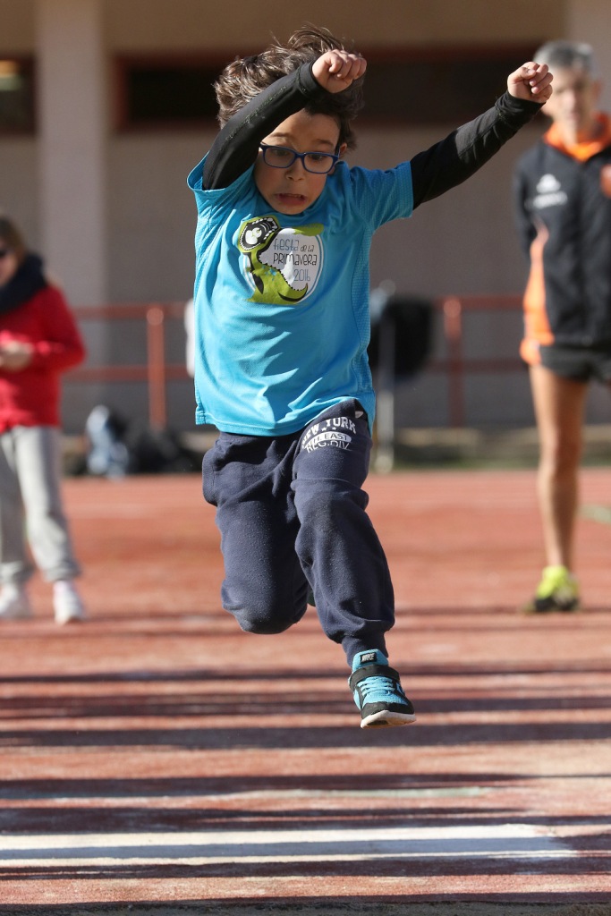 Un niño en pleno vuelo en un salto de longitud