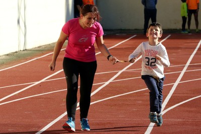 Una monitora ayuda a un niño ciego en un entrenamiento de carrera