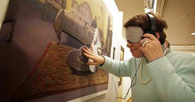 Una mujer percibe los relieves y texturas del cuadro 'Interior con Julia', del pintor Ramón Casas