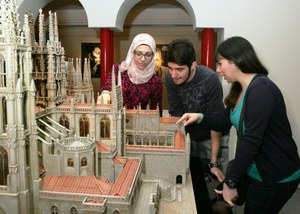 Tres jóvenes sirios observan la maqueta de la Catedral de Burgos