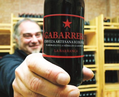 El emprendedor con discapacidad Francisco Javier Terrón muestra una botella de la cerveza artesana que fabrica gracias al apoyo de Fundación ONCE
