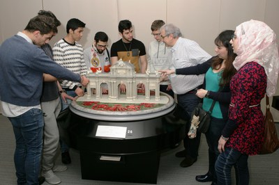 Grupo de refugiados sirios durante su visita al Museo Tiflológico ante la maqueta de la Puerta de Alcalá