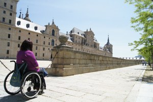 Una persona en silla de ruedas accede a través de una rampa al Monasterio de El Escorial, en Madrid
