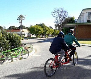 Uno de los alumnos circula en tándem por el recinto del centro acompañado por un guía