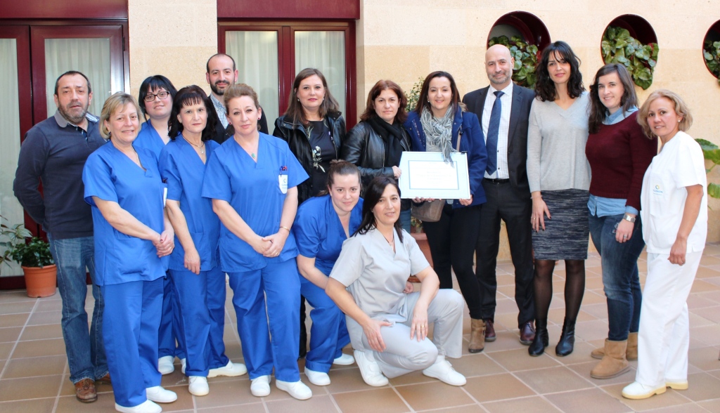 El personal del centro posa, a sus puertas, con el diploma acreditativo del reconocimiento