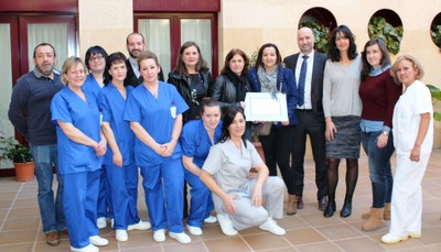 El personal del centro posa, a sus puertas, con el diploma acreditativo del reconocimiento