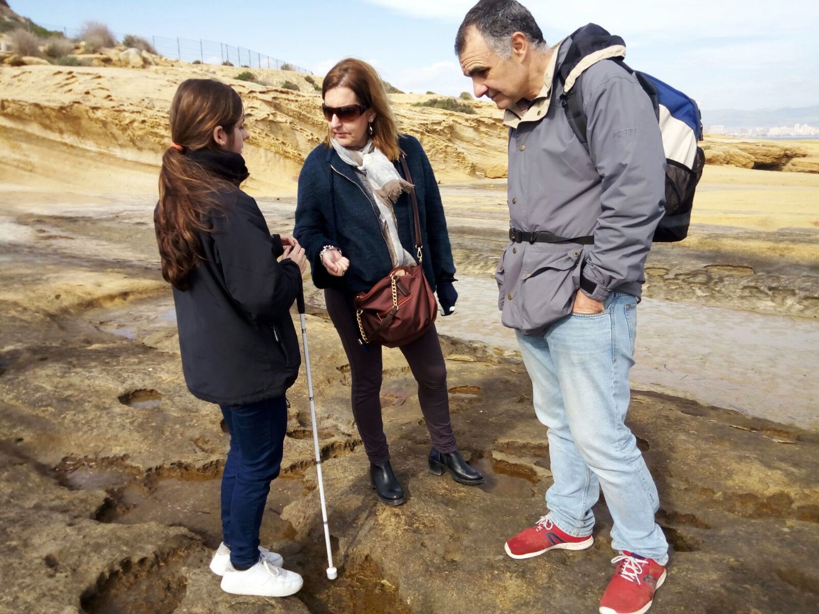 Una alumna consulta sus dudas con los profesores en la playa de la Huerta