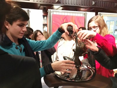 Unos escolares reconocen al tacto una de las esculturas de la exposición de la ONCE