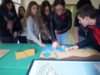 Varios alumnos conociendo al tacto la costa alicantina en un mapa en relieve