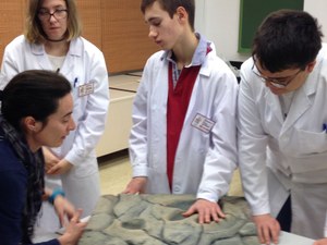 Varios alumnos conversan con un profesora en el taller de Geología