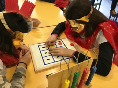 Dos de los escolares practican con un juego de mesa basado en motivos del Imperio Romano y disfrazados de época