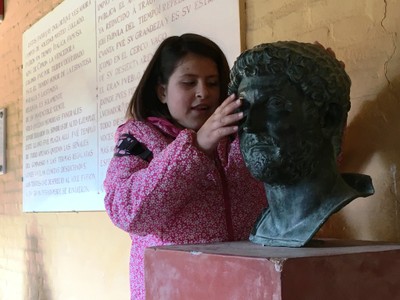 Una pequeña afiliada reconociendo al tacto la escultura de una cabeza patricia