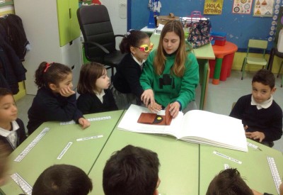 Una niña, provista de unas gafas que le impiden la visión, reconoce al tacto un dibujo en relieve