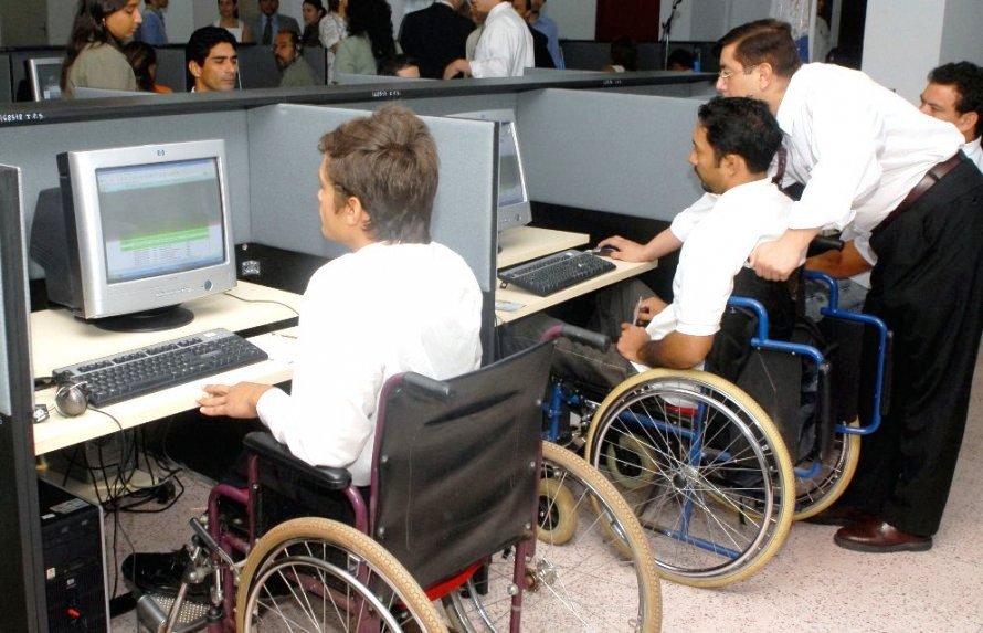 Dos trabajadores en silla de ruedas desarrollando su labor en un centro de proceso de datos