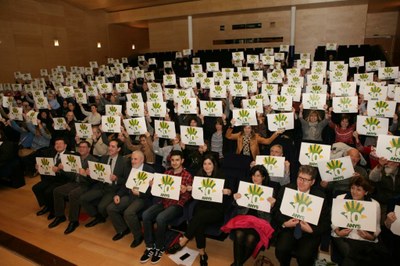 Todos los asistentes al acto muestran el logo del 10 aniversario de FOAPS