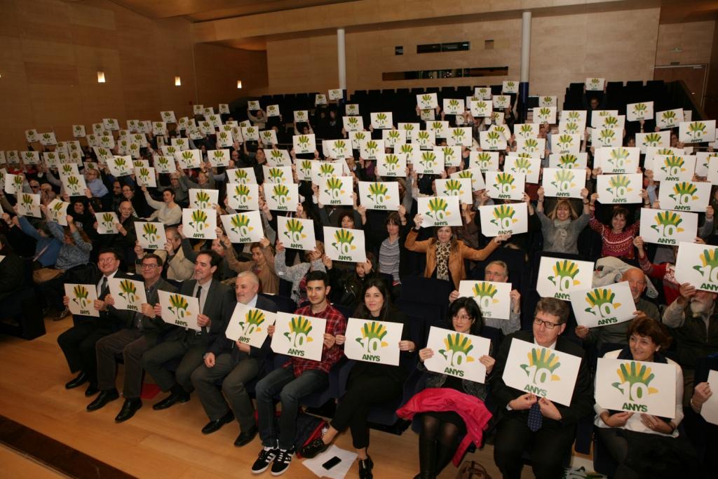 Todos los asistentes al acto muestran el logo del 10 aniversario de FOAPS