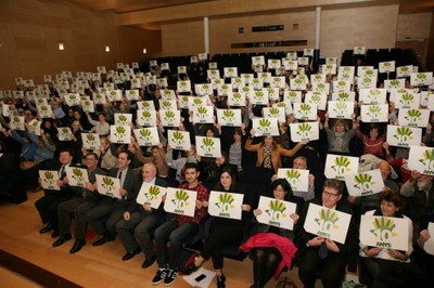 Todos los asistentes al acto muestran el logo del 10 aniversario de FOAPS