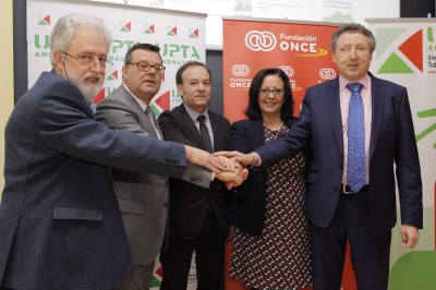 Los firmantes posan uniendo sus manos tras suscribir el convenio