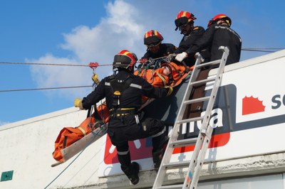 Miembros de la UME trasladan a una persona en camilla por el exterior de un edificio durante el simulacro
