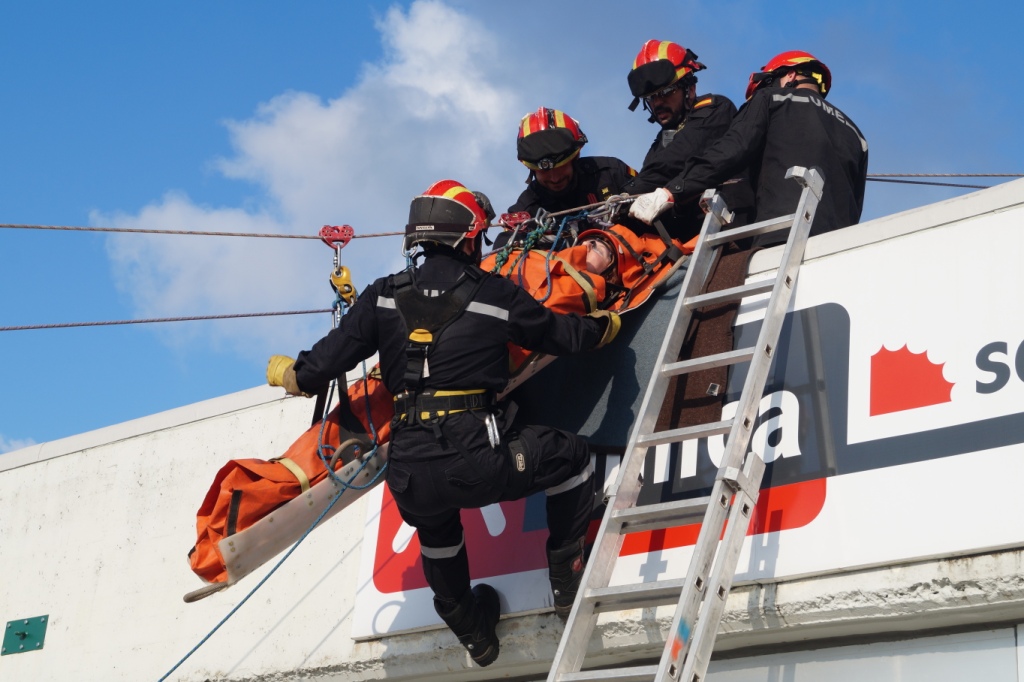 Miembros de la UME trasladan a una persona en camilla por el exterior de un edificio durante el simulacro