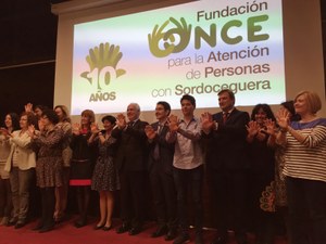 Asistentes y participantes en el acto sobre el escenario