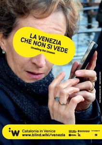 Escuchando el movil con un antifaz donde se lee "la Venecia que no se ve". Foto Institut Ramon Llull