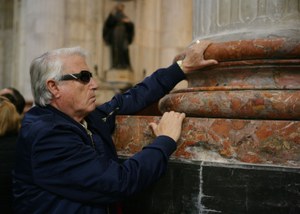 Un pensionista de la ONCE observa al tacto una columna de mármol  