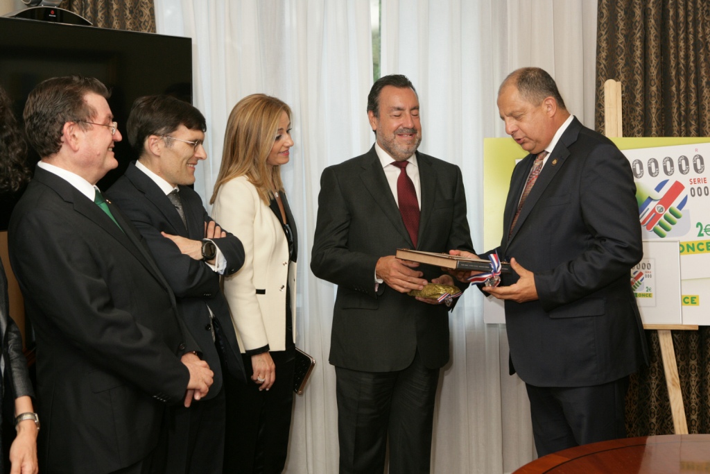 Miguel Carballeda recibe un libro de manos de  Solís Rivera sobre Costa Rica