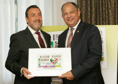 Miguel Carballeda y Luis Guillermo Solís Rivera muestran el cupón enmarcado y dedicado a Costa Rica