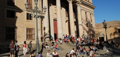 Alumnos sentados en la escalinata de la entrada central de la Universidad de Salamanca