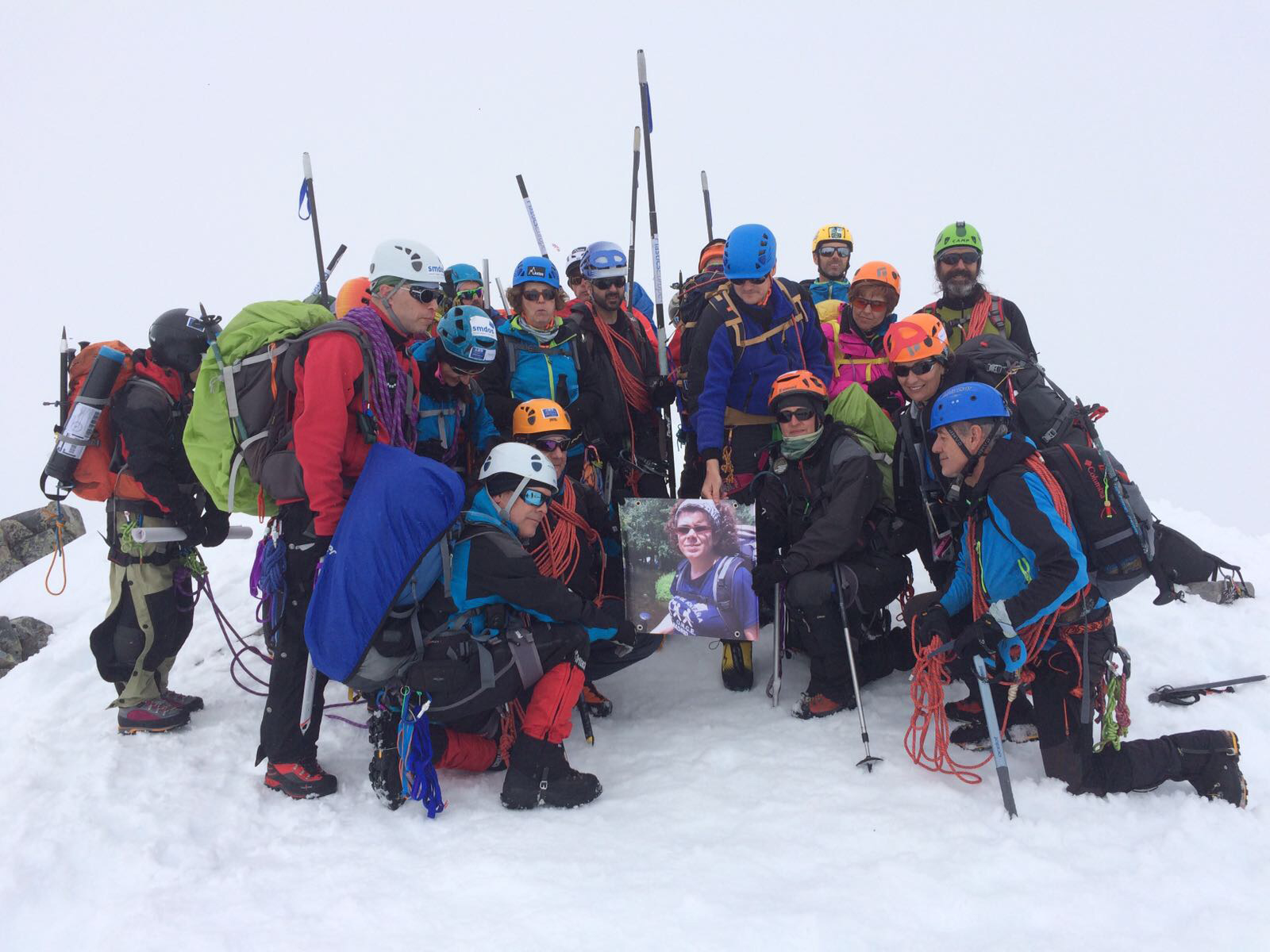 Foto de todo el grupo en la cumbre con la foto de una compañera recientemente fallecida