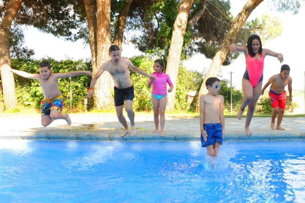 Un monitor salta a la piscina con un grupo de niños con discapacidad visual