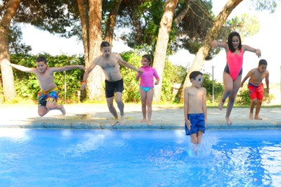 Un monitor salta a la piscina con un grupo de niños con discapacidad visual
